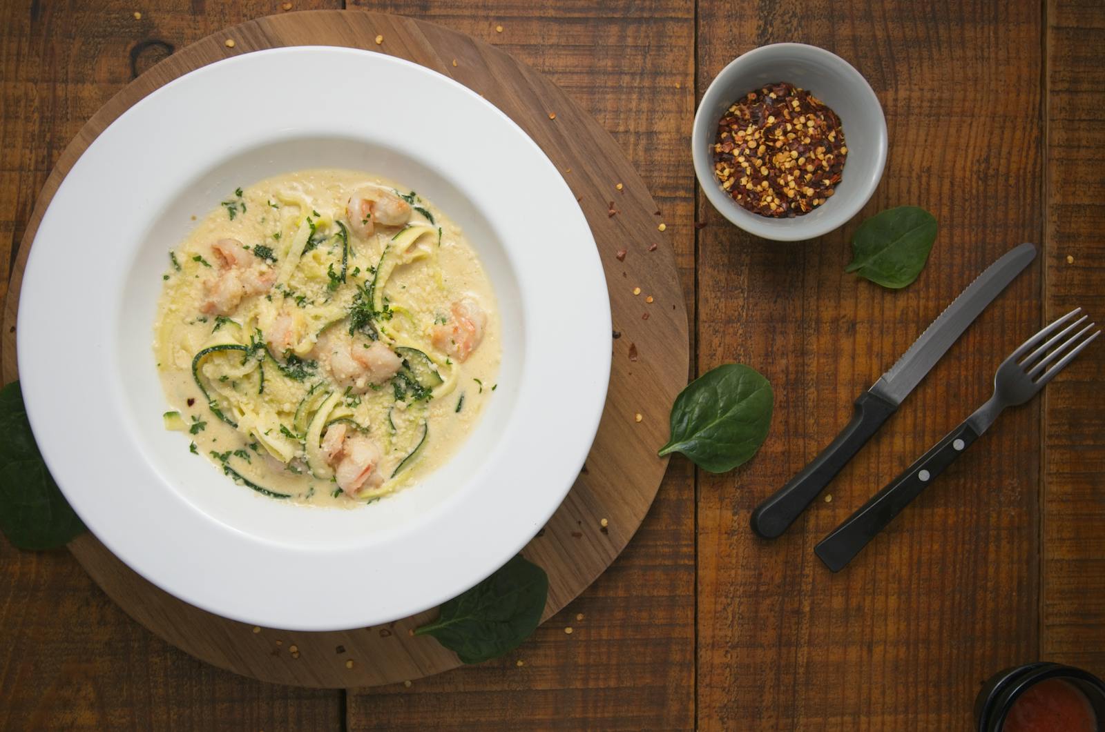 Tallerken med scampi og zucchini-nudler på trebord