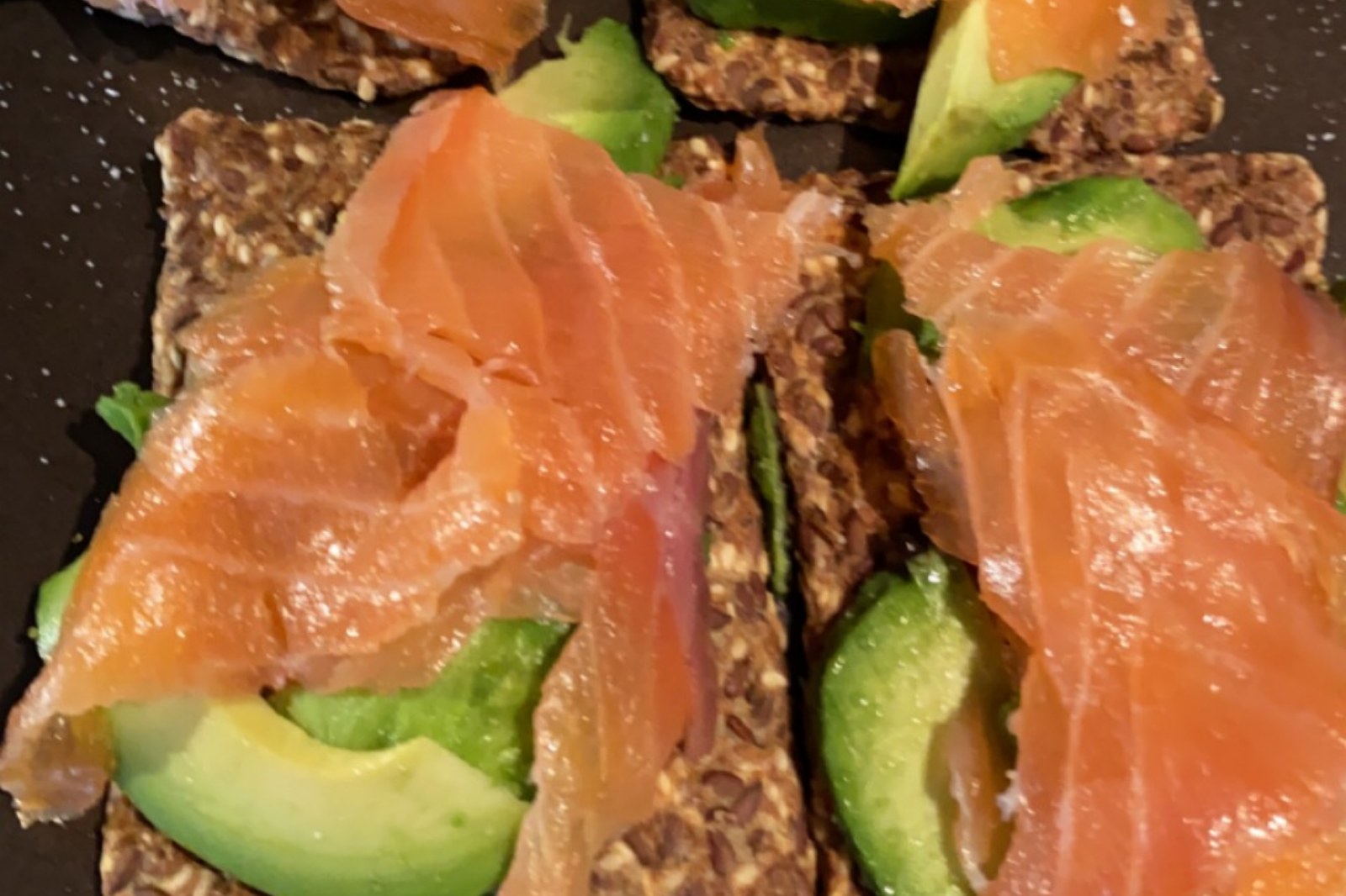 Frøknekkebrød med avocado og røkelaks på tallerken